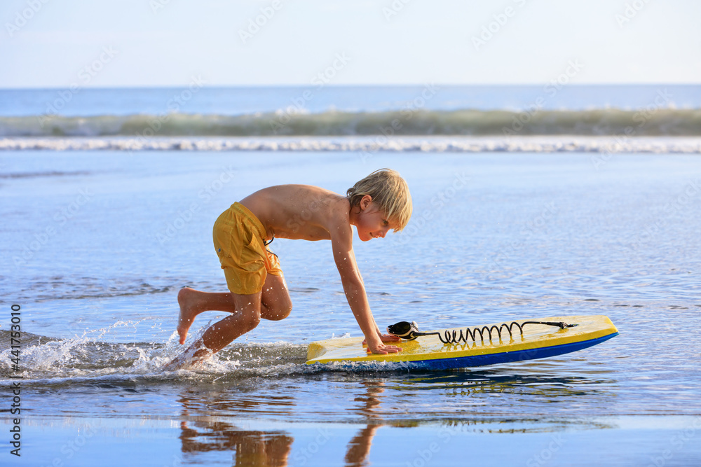 Boy with bodyboard have fun on sea beach