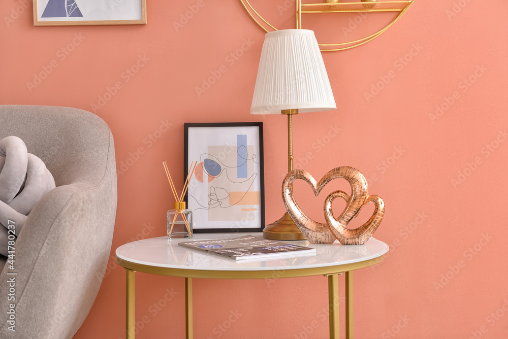 Table with picture and decor near color wall