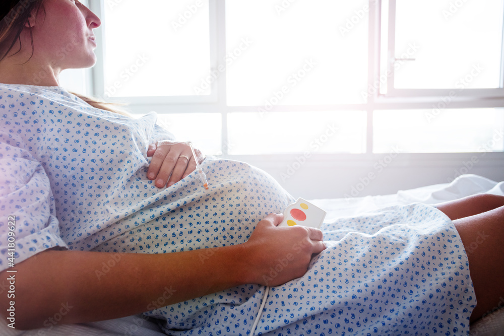 一名孕妇躺在病床上的腹部特写