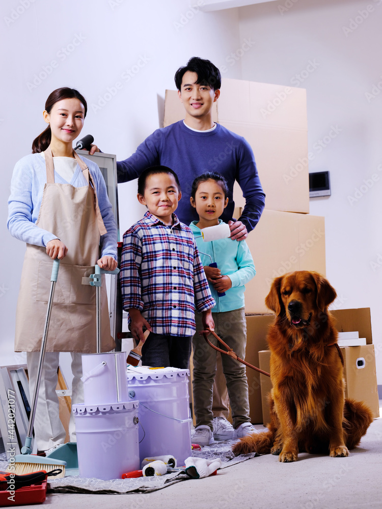 一个幸福的四口之家和一只宠物狗装饰着房子
