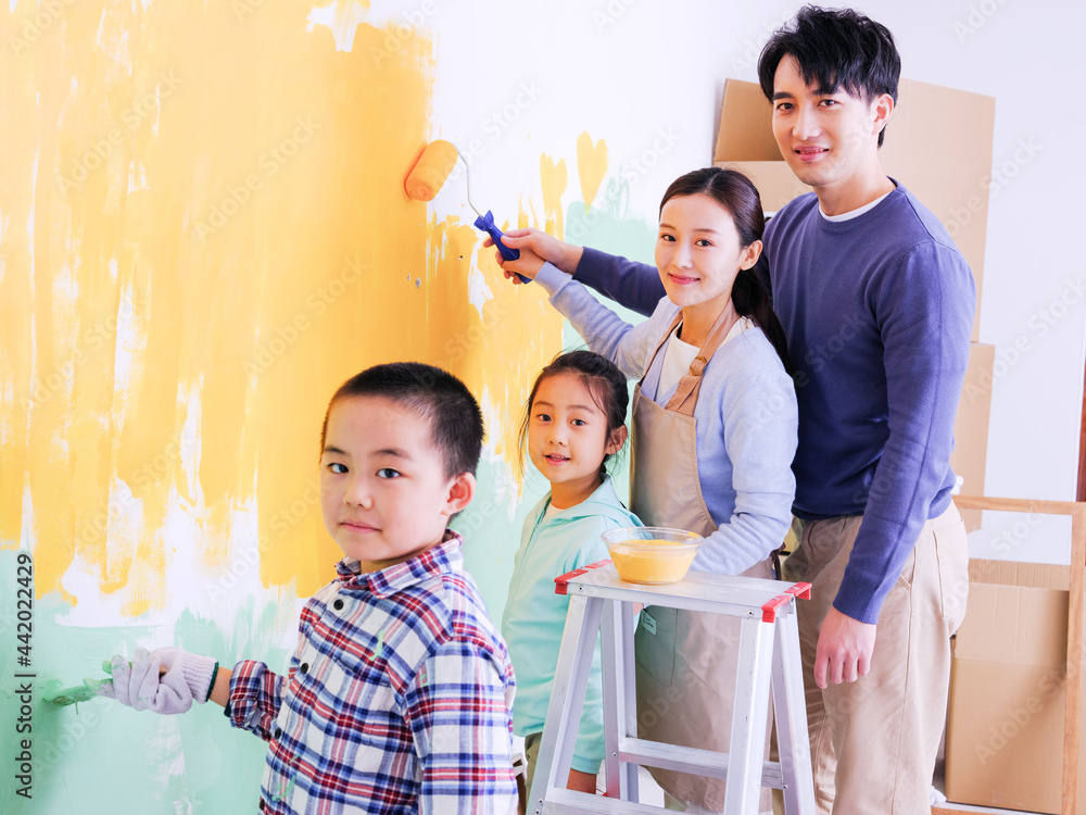 A happy family of four painting walls