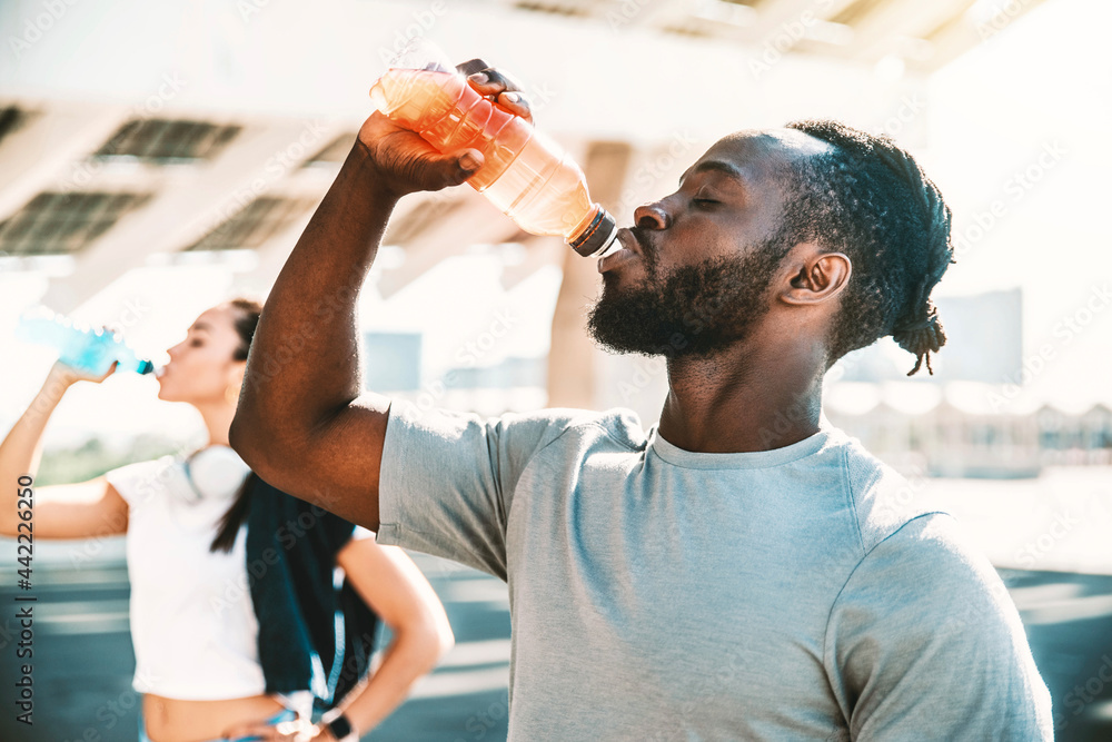 健身非洲运动员户外饮用能量饮料-健身人士下班后休息