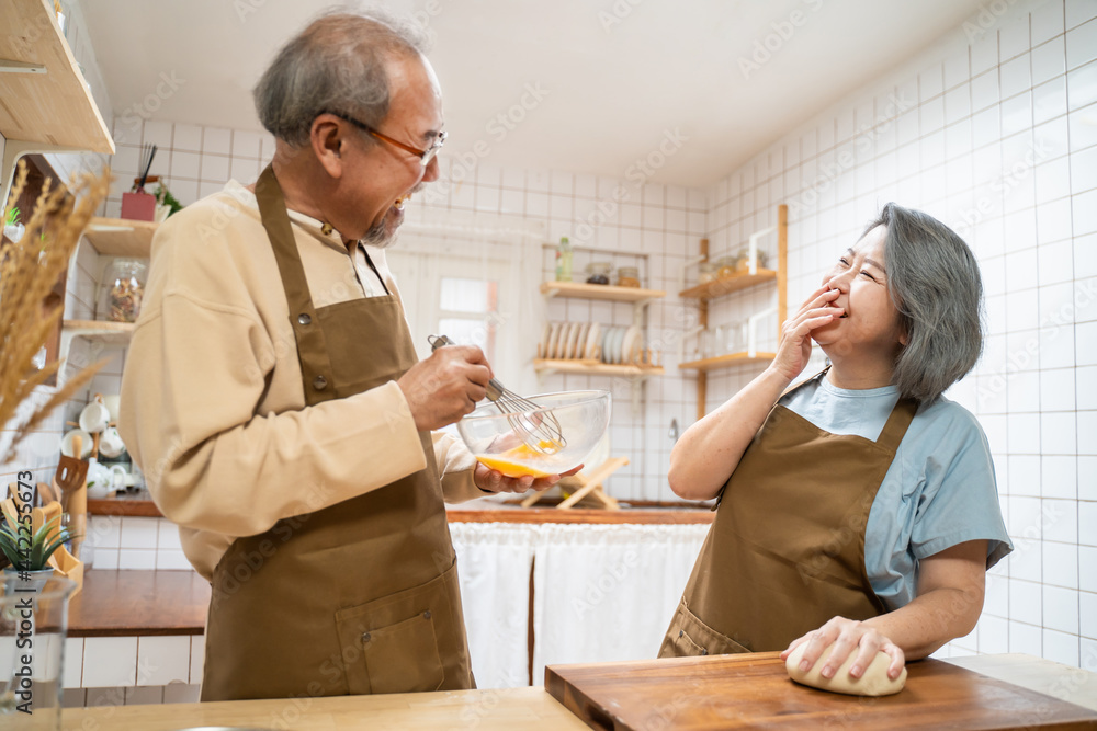亚洲幸福老年夫妇喜欢在家里的厨房做饭。