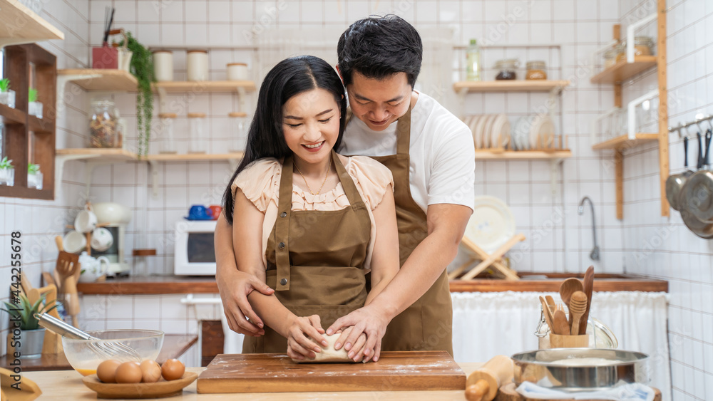 亚洲新婚夫妇待在家里，在厨房里共度时光。