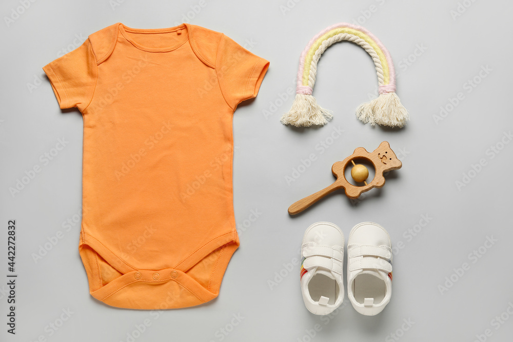 一套浅色背景的婴儿衣服、鞋子和玩具