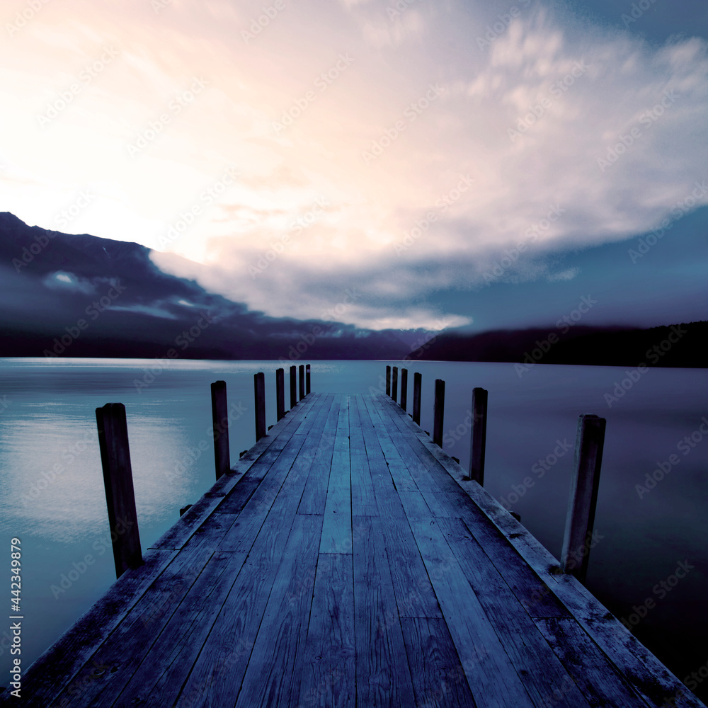 日出时的船码头和平静的湖面，新西兰。