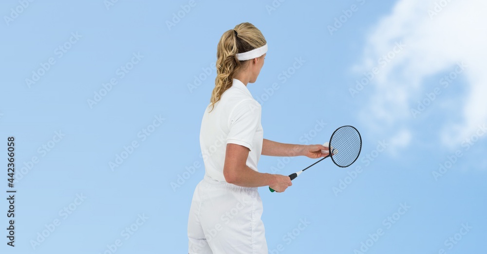 女羽毛球运动员在蓝天上与云比赛的后视图
