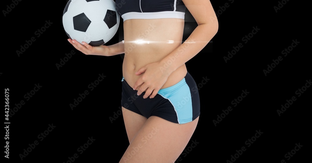 女运动员在黑色背景下拿着足球的中段