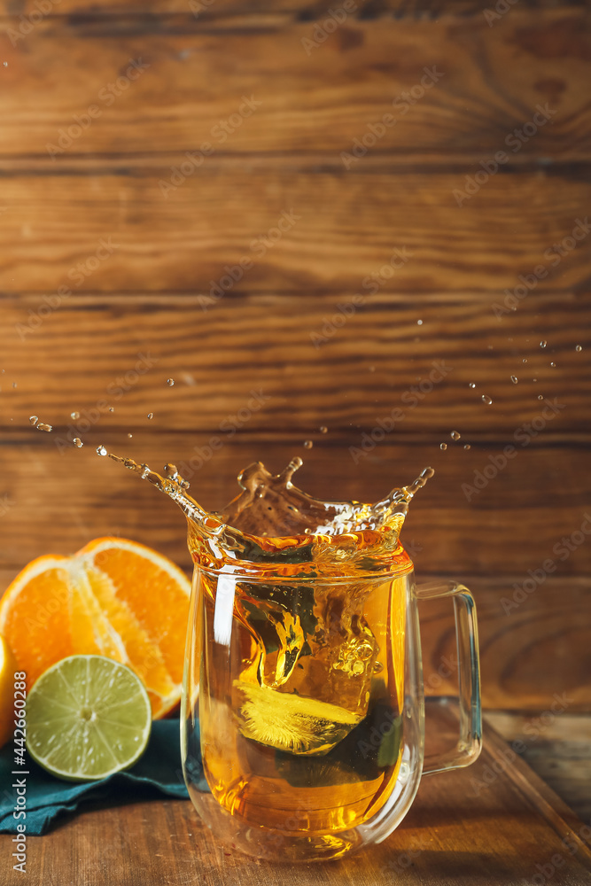 玻璃杯热柑橘茶，木底飞溅