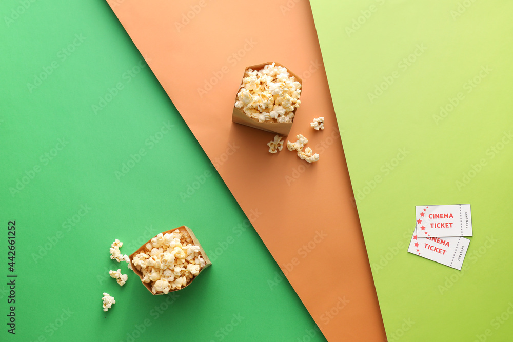 彩色背景上有美味爆米花和电影票的纸袋