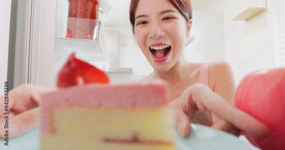woman takes cake from refrigerator