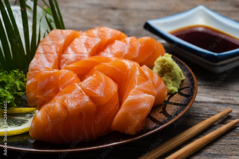 白盘子里的寿司三文鱼、金枪鱼、寿司虾和芥末。