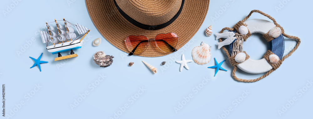 蓝色背景下的贝壳、帽子和太阳镜的夏季海滩背景设计理念。