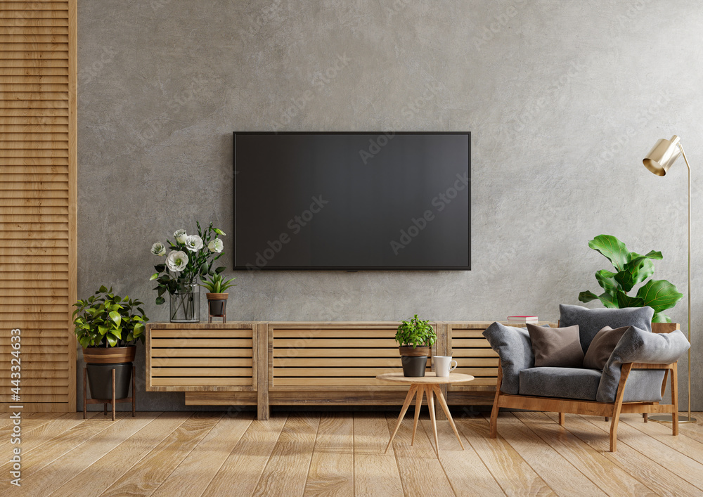 实体橱柜电视墙安装在水泥房里，配有扶手椅和桌子。