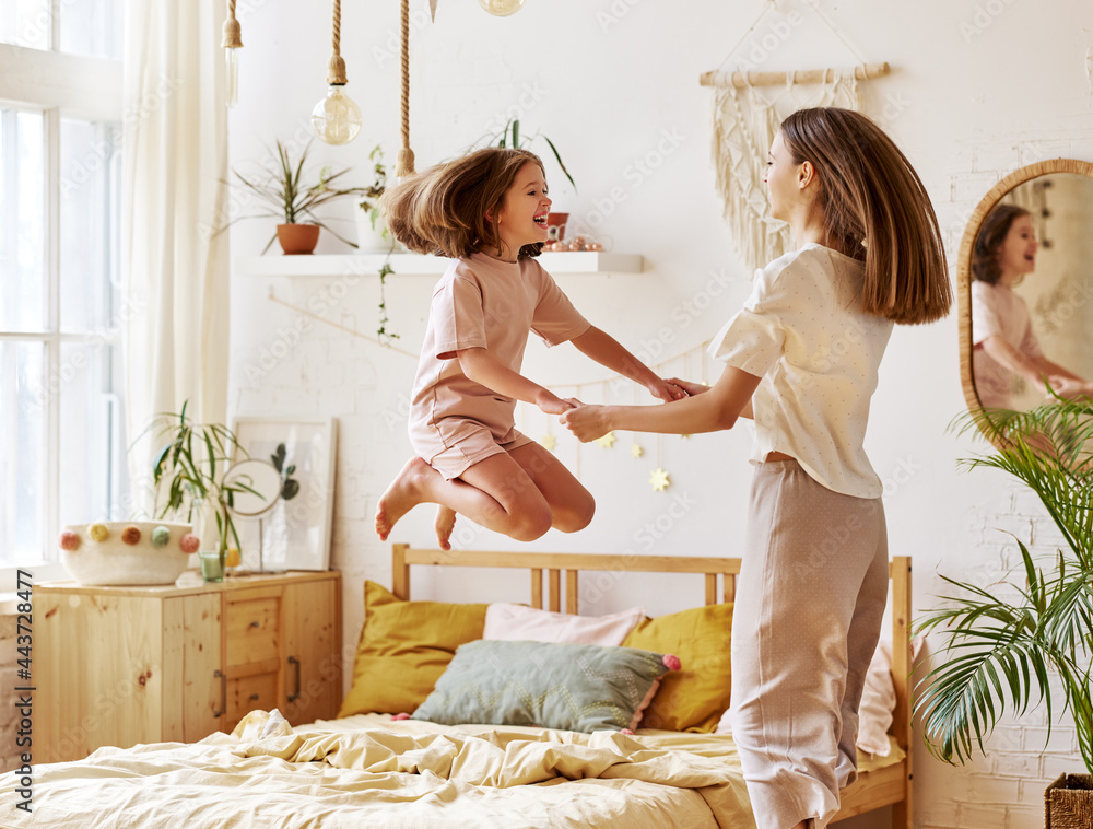 年轻和年长的高加索姐妹在卧室里一起玩得很开心，兴奋可爱的学前班女孩