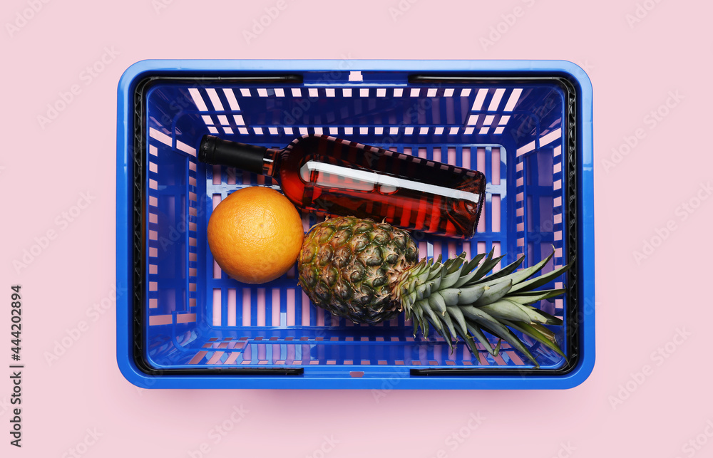 购物篮，背景是一瓶葡萄酒和水果