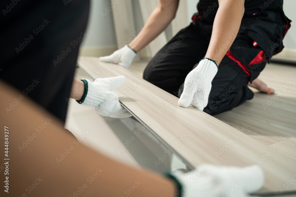 工匠工人在家里的地板上安装层板的特写。