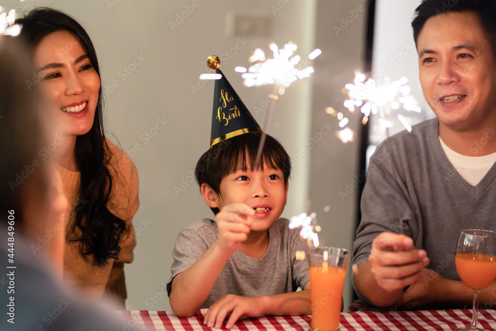 亚洲幸福大家庭，父母与年幼的孩子一起玩火花。