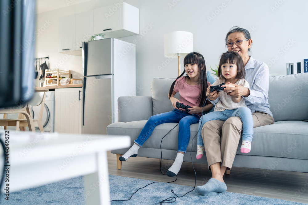 亚洲幸福家庭待在家里，奶奶和小女孩玩游戏。