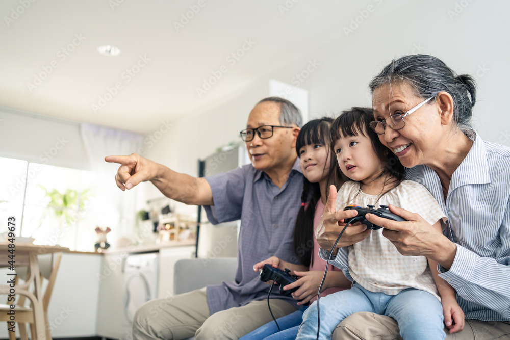 亚洲幸福家庭留守爷爷和小女孩玩游戏。