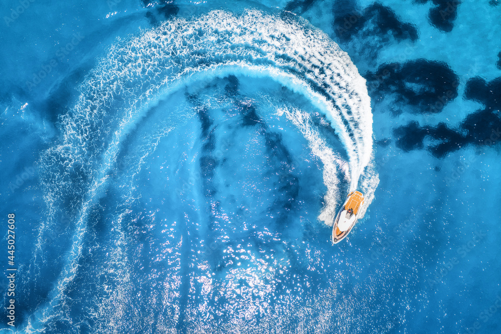 夏季阳光明媚的日子，快艇在清澈的蓝色水中的鸟瞰图。fas的无人机俯视图