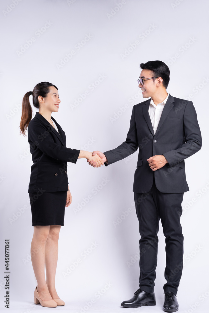 白人背景下的亚洲商人和女商人握手