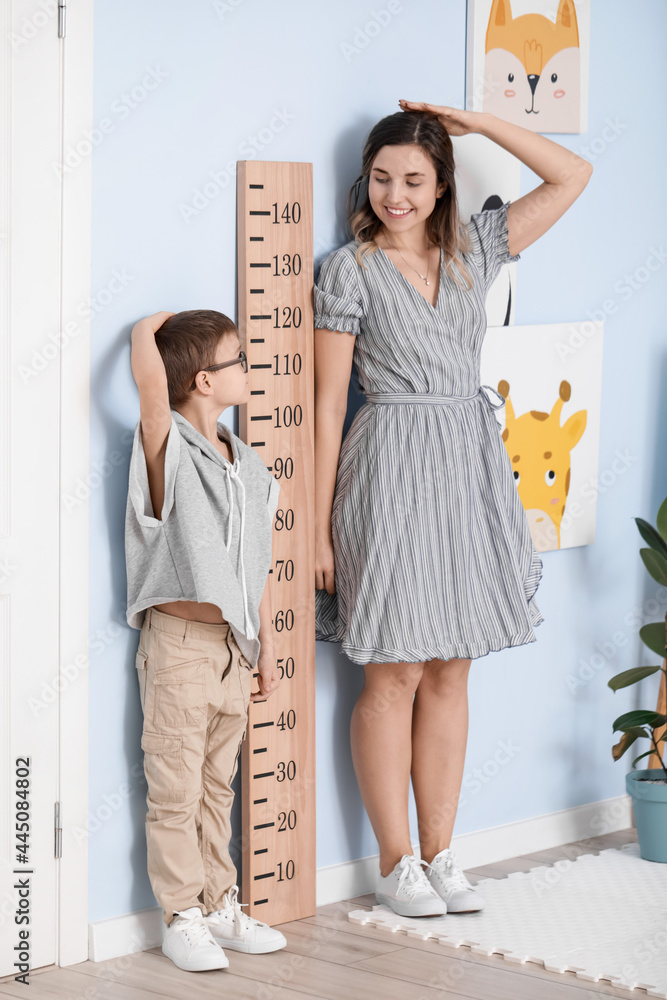 小男孩和他的妈妈在家测量身高