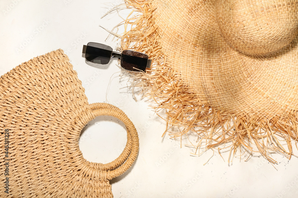 浅色背景下的时尚帽子、包包和太阳镜
