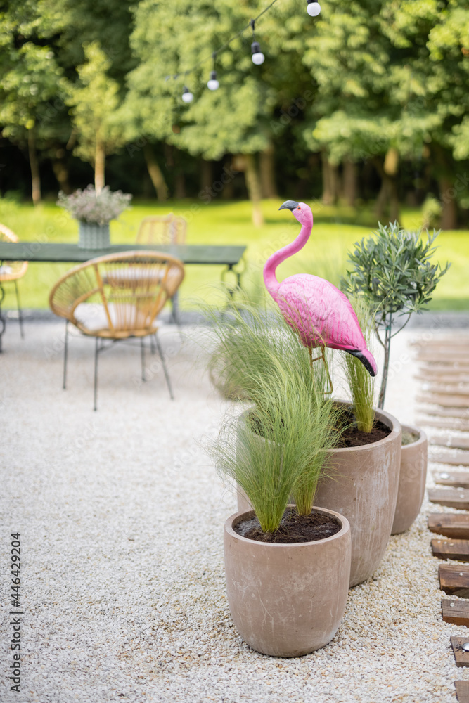 美丽的后院，自然波西米亚风格，配有花园家具、绿色和粉色火烈鸟