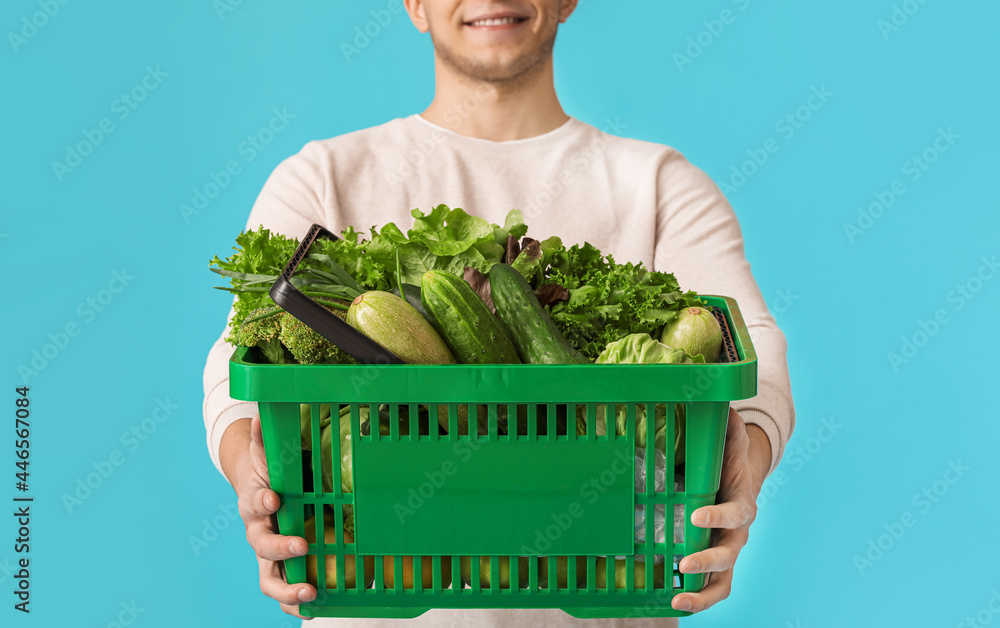 年轻人和购物篮，背景是新鲜蔬菜，特写