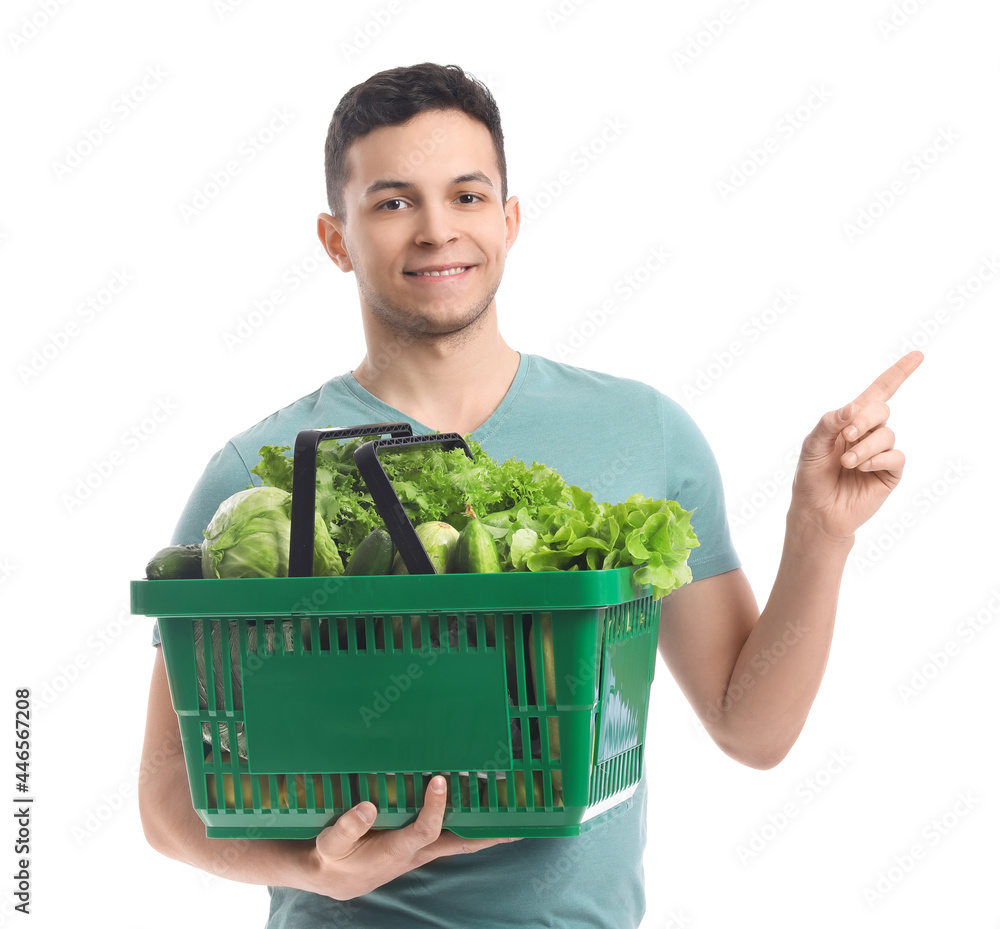 拿着新鲜蔬菜的年轻人指着白底上的东西