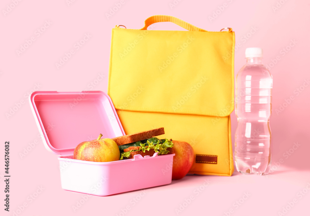 袋子、一瓶水、午餐盒，背景是三明治和苹果