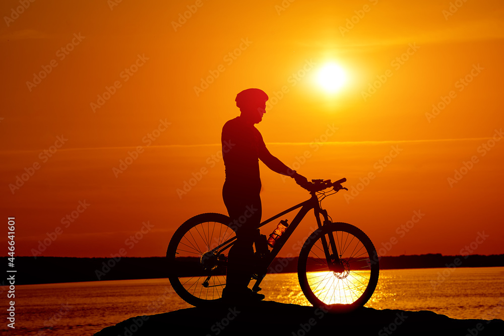 比赛自行车手的剪影。自行车手太阳后面的影子。