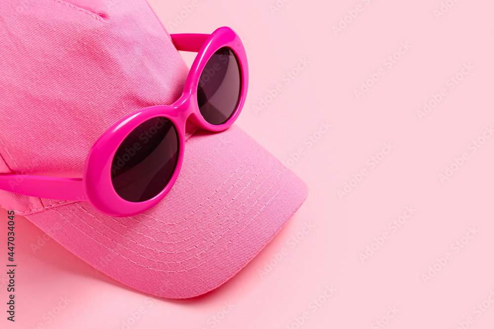彩色背景带太阳镜的时尚帽子，特写