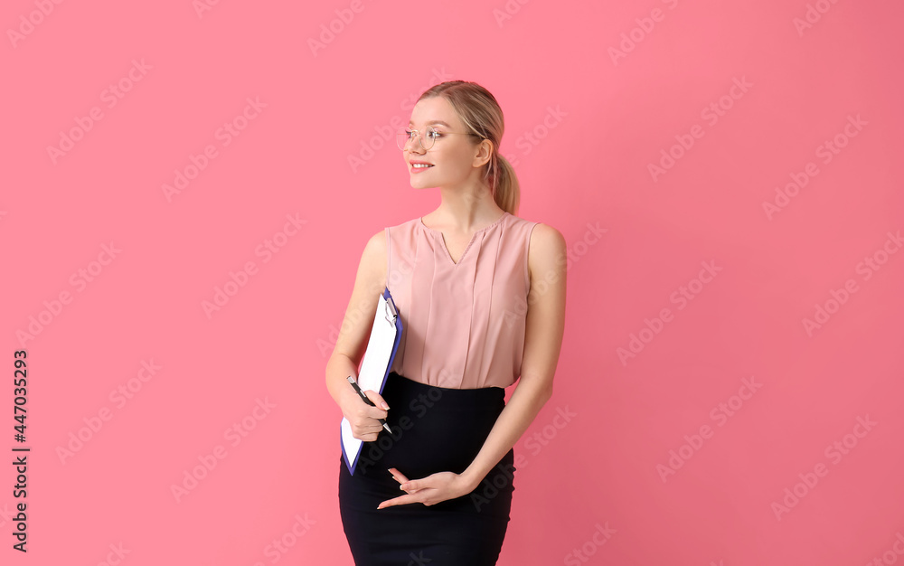 怀孕的年轻女性，彩色背景上有剪贴板