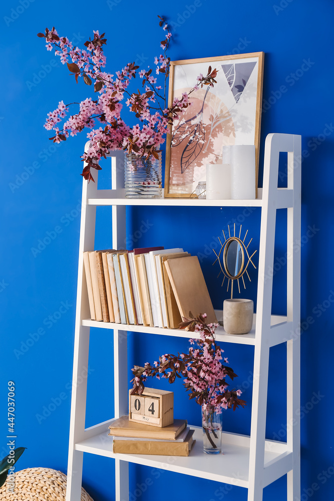 彩色墙附近枝繁叶茂的书架