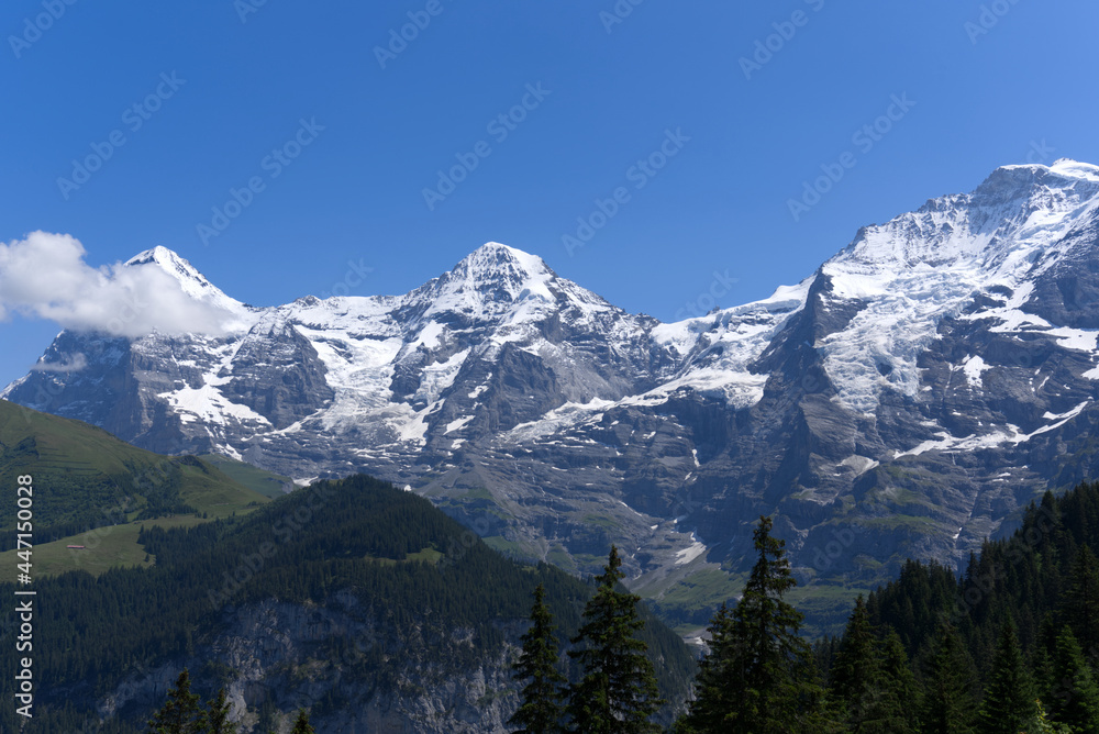 Mountain peaks Eiger, Mönch (Monk) and Jungfrau (Vrigin) at Bernese highland on a sunny summer day w