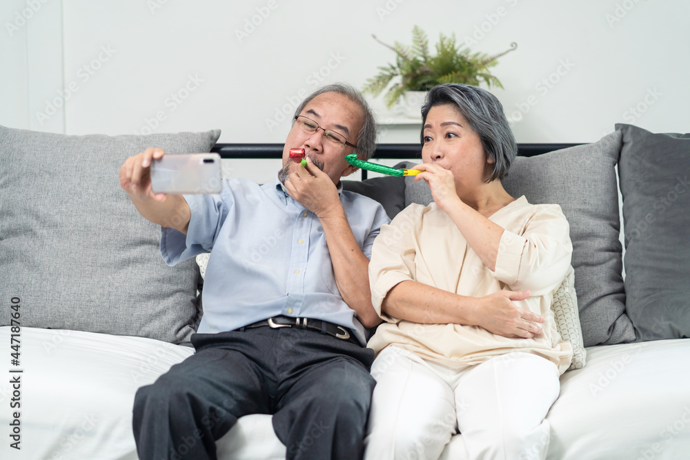 亚洲老年夫妇与家人使用电话远程视频通话。
