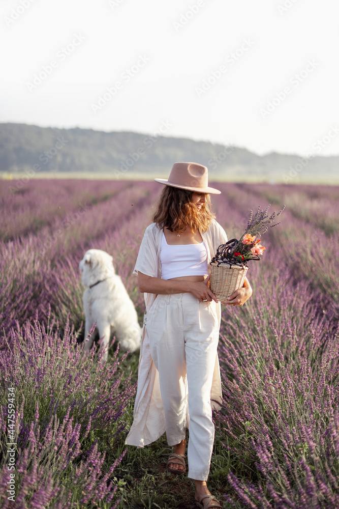 女人待在盛开的薰衣草地上，手里拿着一桶花，享受大自然的美丽。S