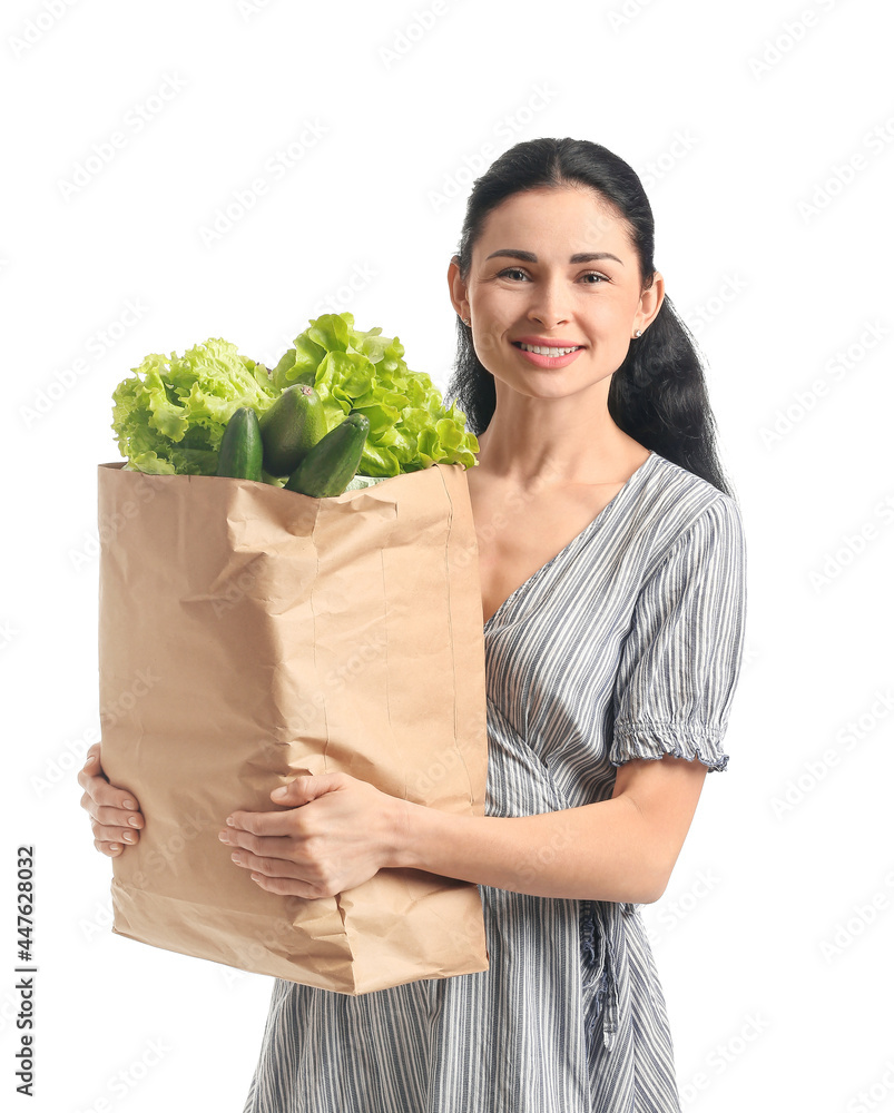 年轻女子拿着白底新鲜蔬菜的纸袋