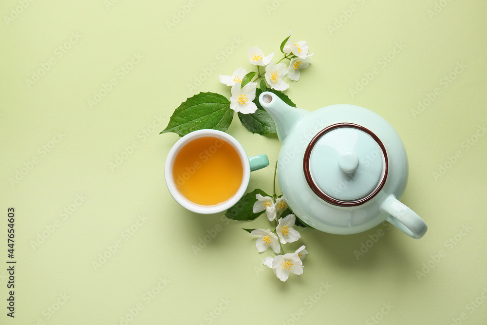 以一杯茉莉花茶、茶壶和花为背景的彩色构图