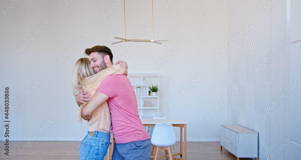 浪漫的新婚夫妇拿着棕色的大纸箱把东西放在新公寓的地板上