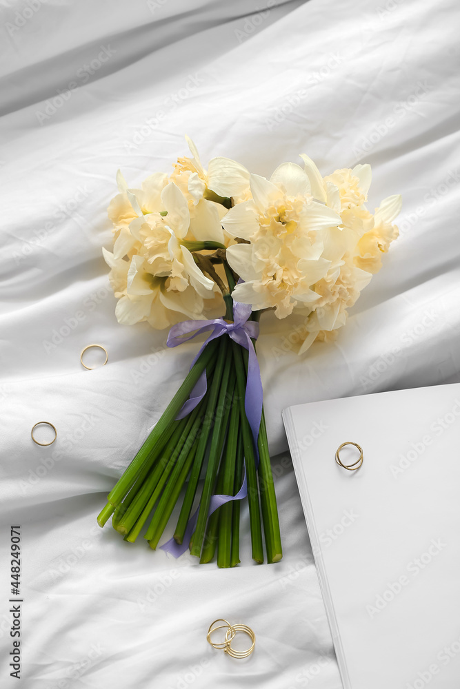 美丽的一束水仙花，床上有金色的戒指