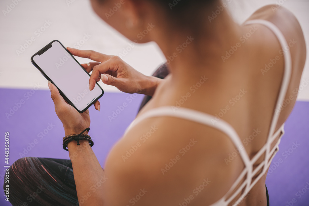 女性在瑜伽锻炼后使用手机