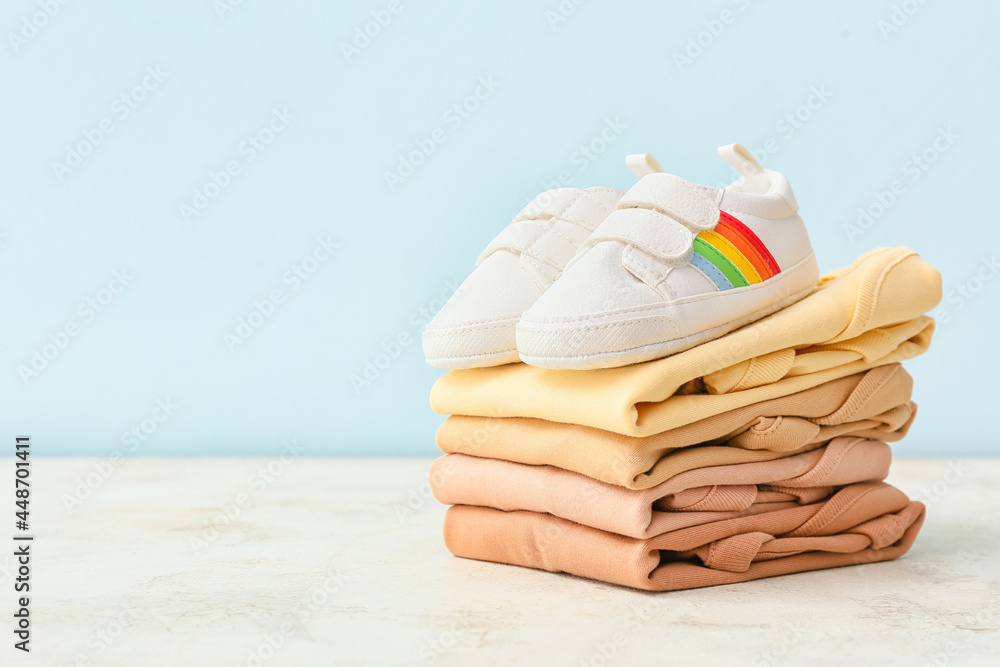 彩色背景上的婴儿衣服和鞋子堆叠