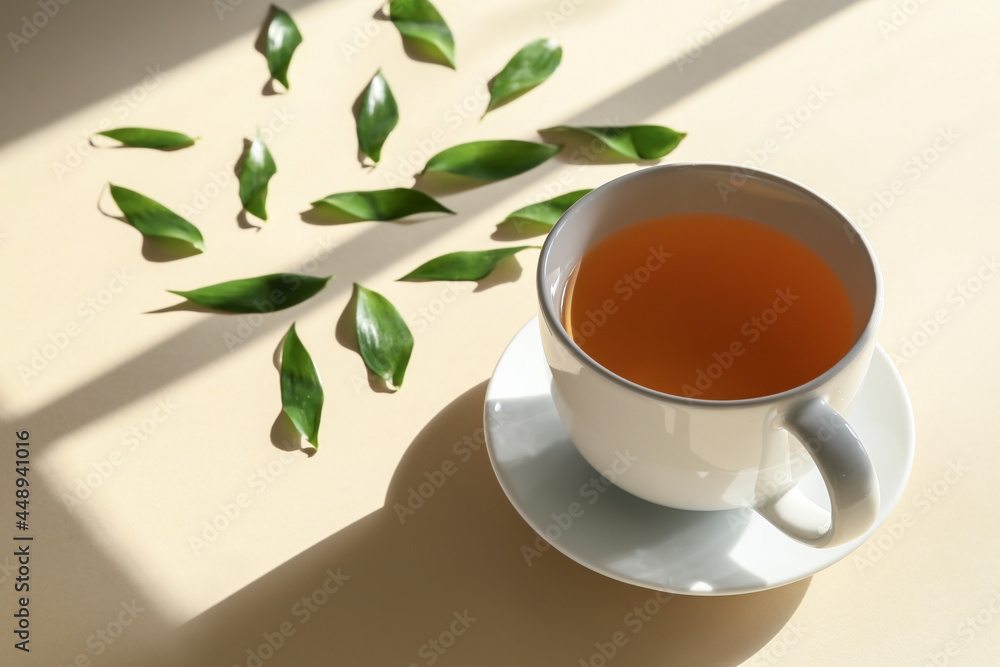 彩色背景的一杯茶和绿叶，特写