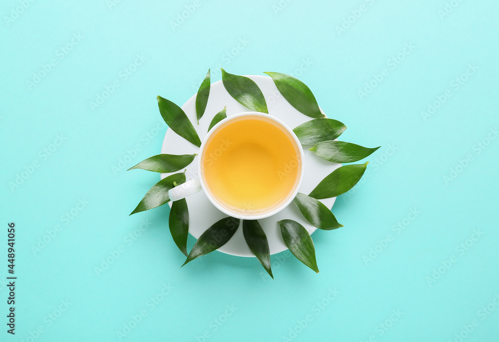 彩色背景的一杯茶和绿叶
