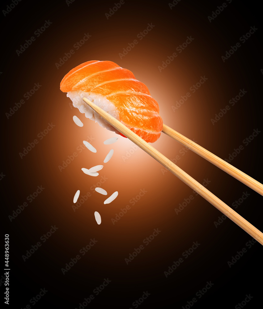黑底筷子夹三文鱼的新鲜传统日本寿司