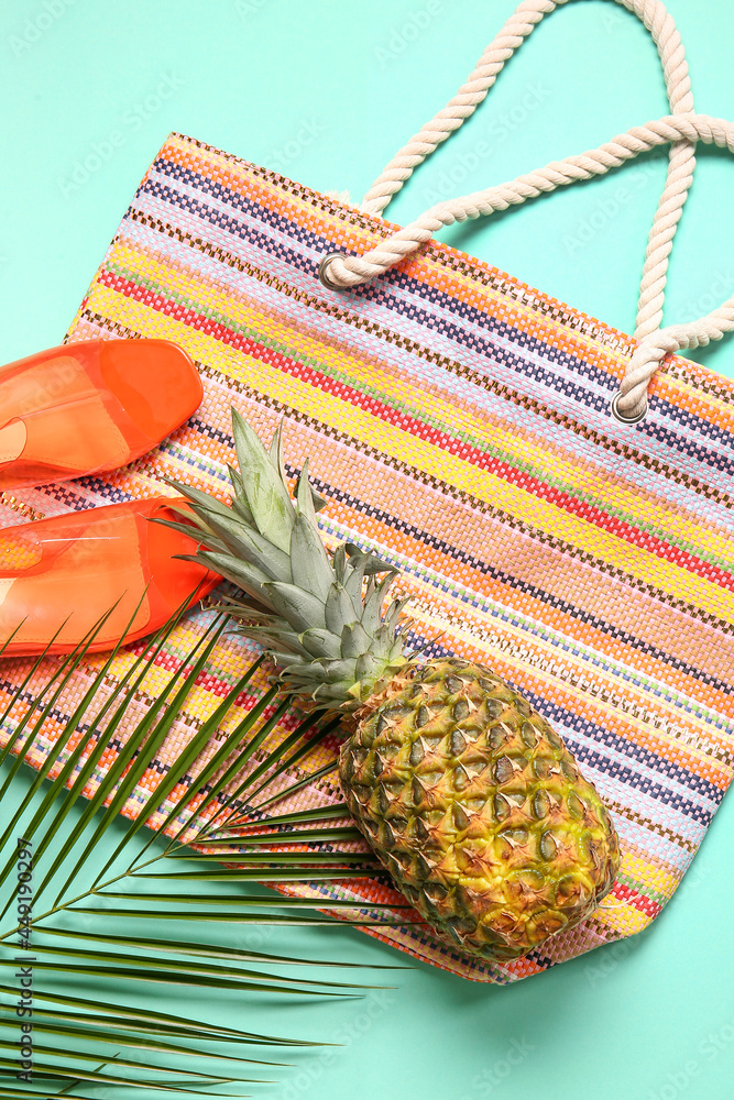 时尚的鞋子、包包、菠萝和棕榈叶，彩色背景，特写