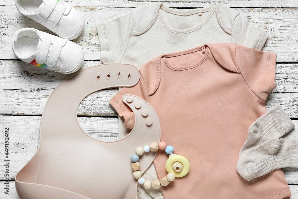 浅木背景的婴儿衣服、鞋子和配饰，特写
